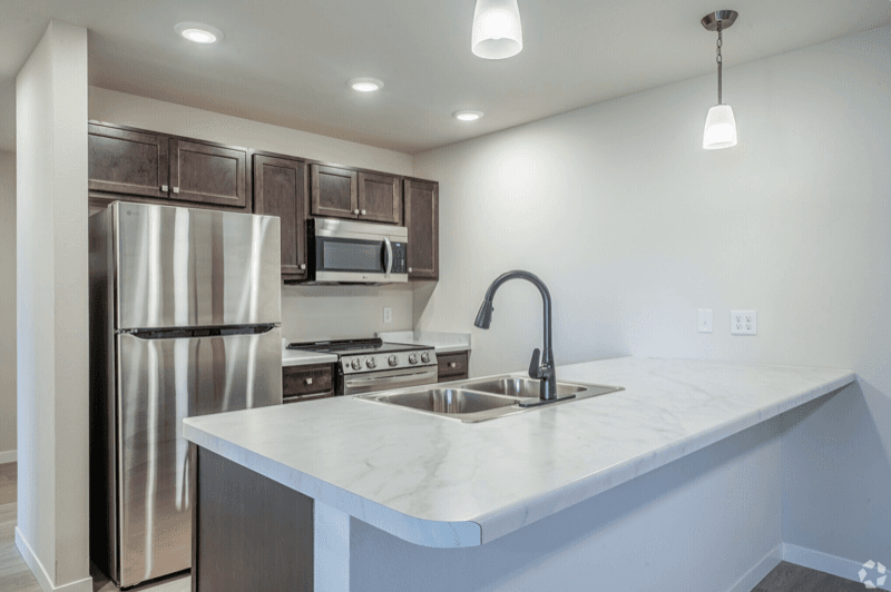 Modern kitchen with stainless steel appliances and white countertops