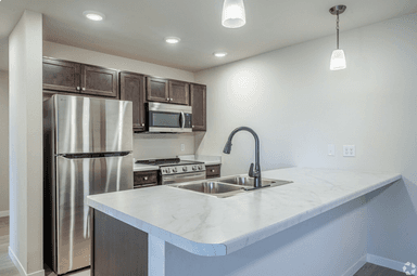 Modern kitchen with stainless steel appliances and white countertops