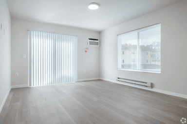 Spacious living room with large windows and vinyl flooring