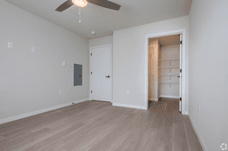 Comfortable bedroom with ceiling fan and walk-in closet