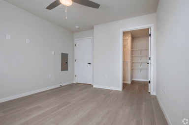 Comfortable bedroom with ceiling fan and walk-in closet